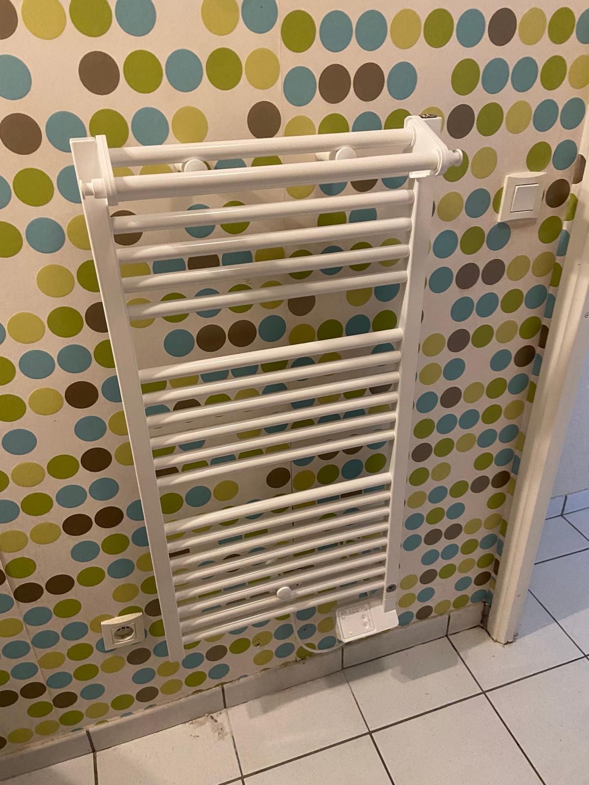 Sèche-serviettes électrique blanc posé en salle de bain